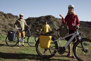 This image shows three riders staggered from front to back with their bikes modelling the Fjällräven X Specialized collection