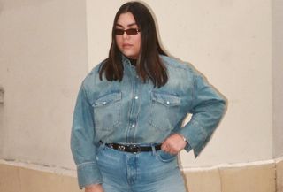 Gen Z Editor wearing denim shirt, denim jeans, black belt, and sunglasses standing on Parisian street.