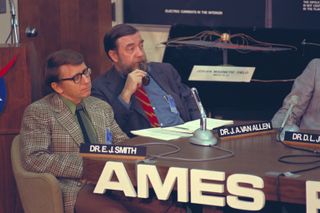 Legendary space scientist James van Allen is seen smoking a pipe alongside physicist Edward Smith at a Pioneer 11 press conference in 1974.