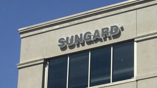 A close up shot of a corner of a building with the word Sungard displayed, with a blue sky in the background