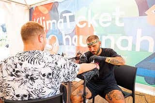 A person getting tattooed at a festival