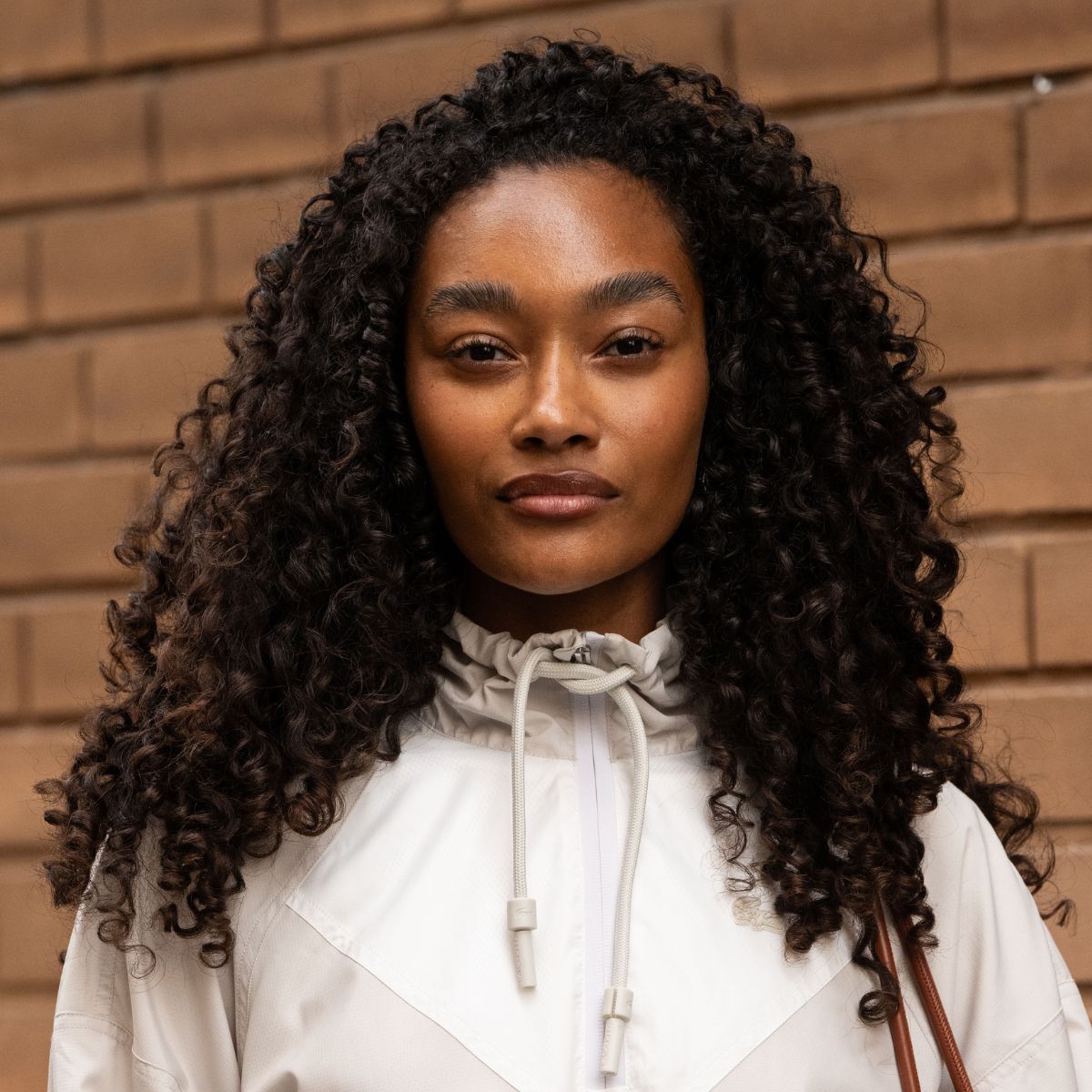 headshot of woman with long dark brown curly hair