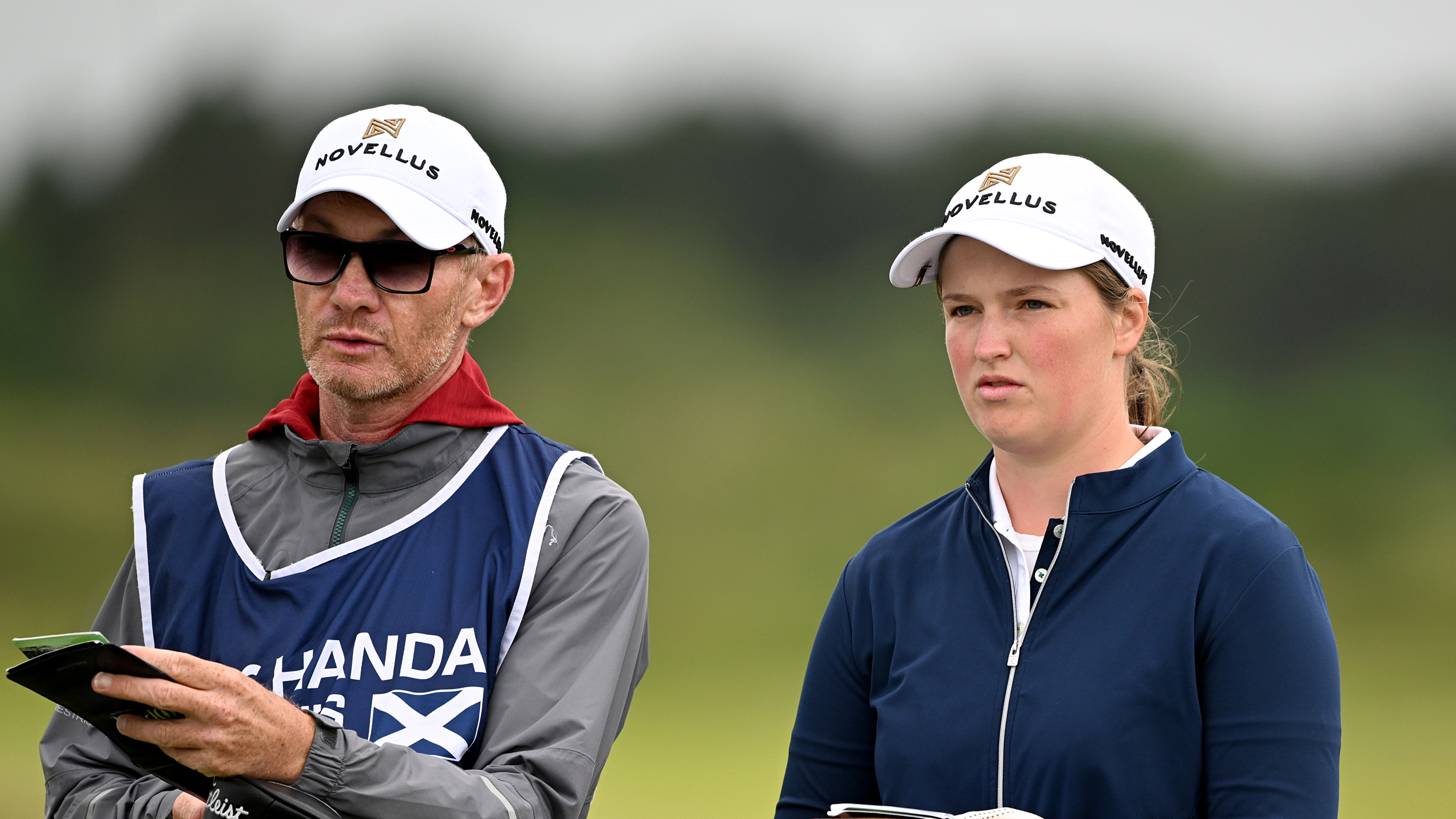 Caddie Dermot Byrne (left) and Lottie Woad discuss a shot during the 2025 ISPS HANDA Women&#039;s Scottish Open