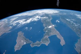 A new photo of Earth from space offers a clear view of southern Italy, a peninsula commonly referred to as "the boot," and the island of Sicily. The northern part of the country is obstructed by a blanket of clouds that stretches as far as the eye can see. An astronaut at the International Space Station captured this view of Italy as it was passing over the Mediterranean Sea on June 9. At the time, the space station was orbiting at an altitude of 255 miles (410 kilometers), which is more than high enough to be able to see the curvature of the Earth.