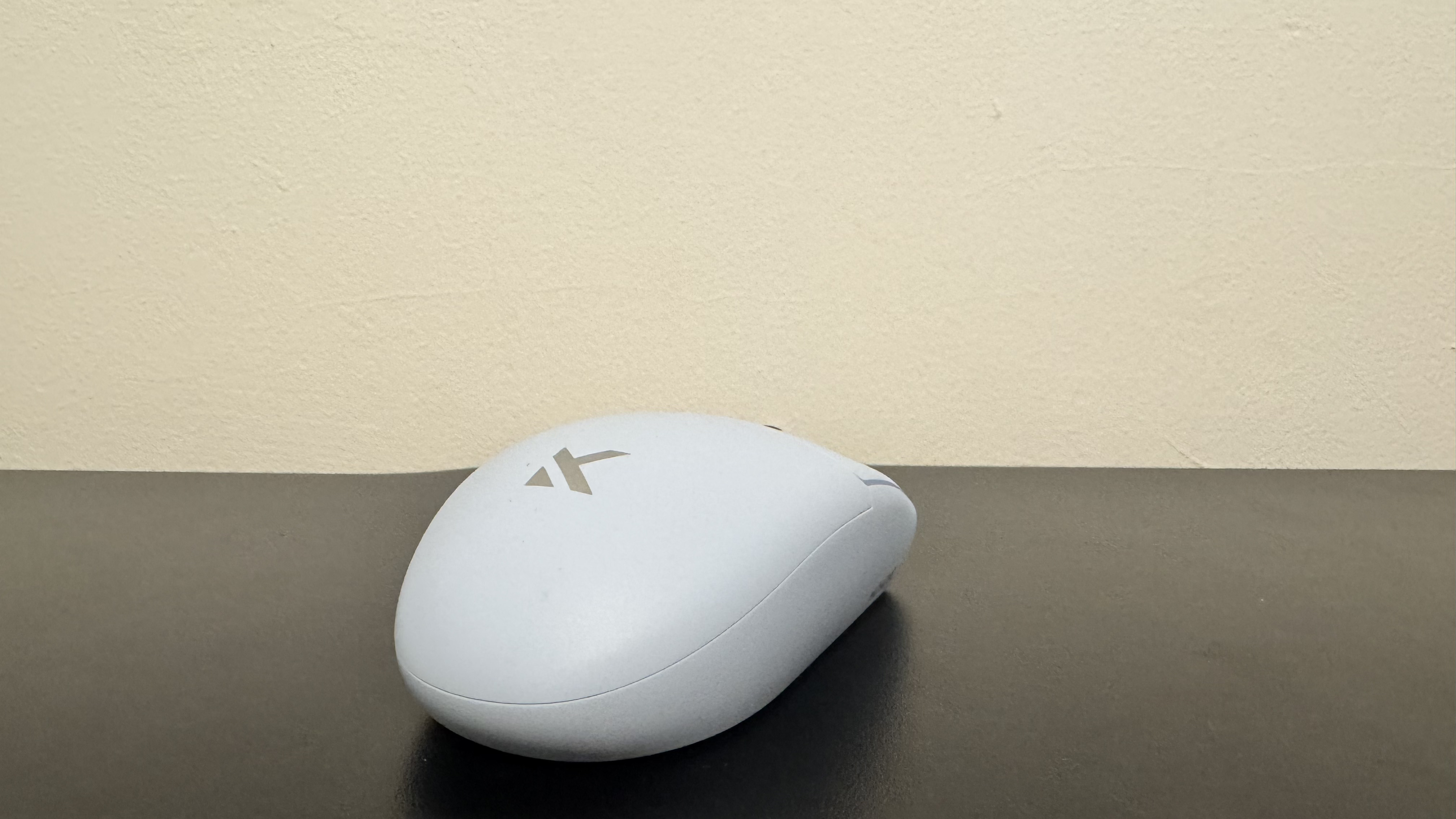 The blue Mchose G3 V2 gaming mouse from the back on a black desk