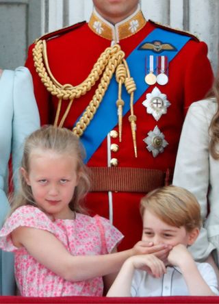 Prince William, Duke of Cambridge looks on as Savannah Phillips puts her hand over Prince George of Cambridge's mouth whilst they stand on the balcony of Buckingham Palace during Trooping The Colour 2018 on June 9, 2018