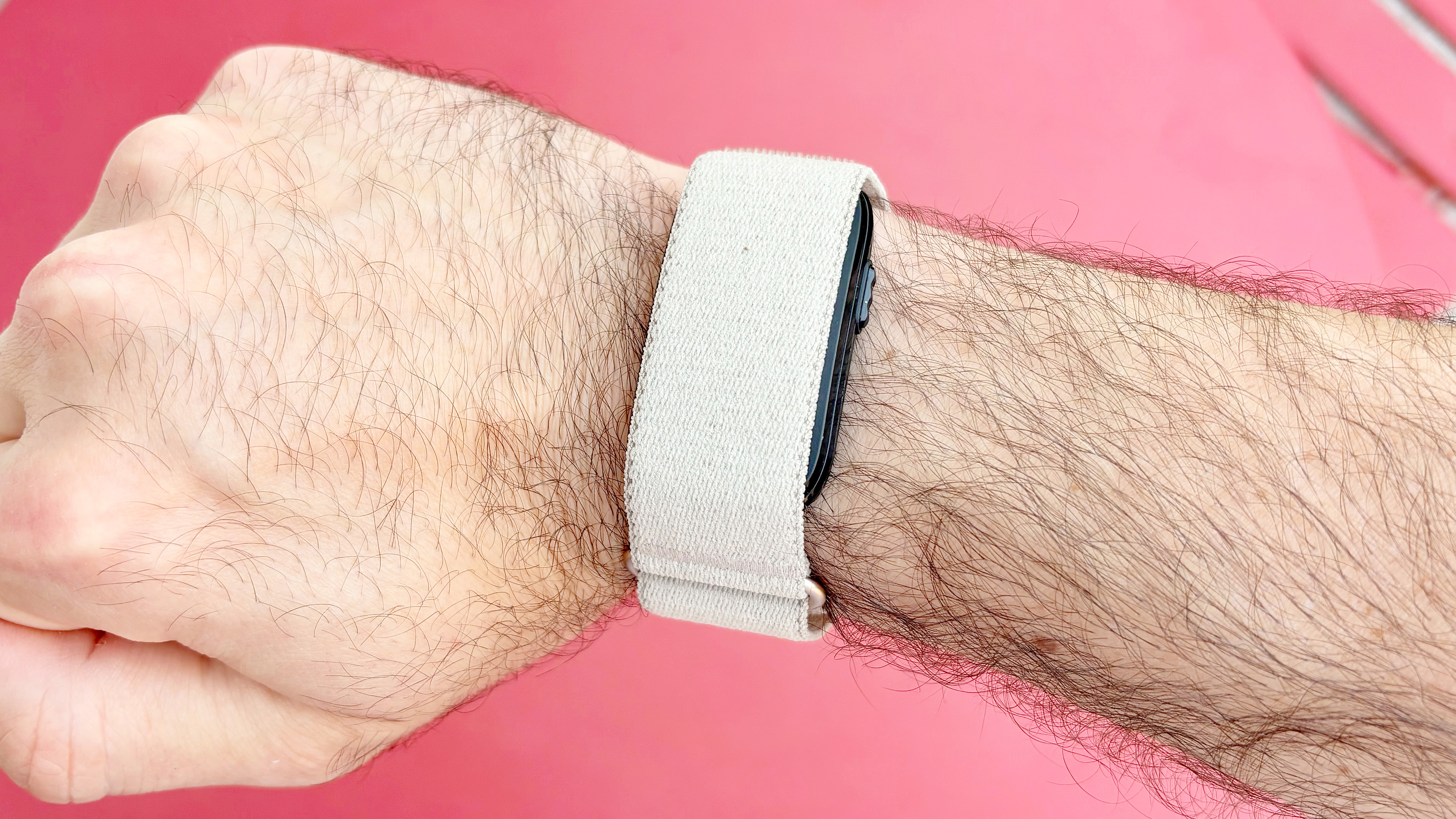 Close-up of the Garmin Cirqa on the writer's wrist against a red background
