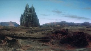 Still from the science fantasy movie Krull (1983). A giant black fortress (an interplanetary spaceship/castle) lands on the desert-like terrain of the planet Krull.