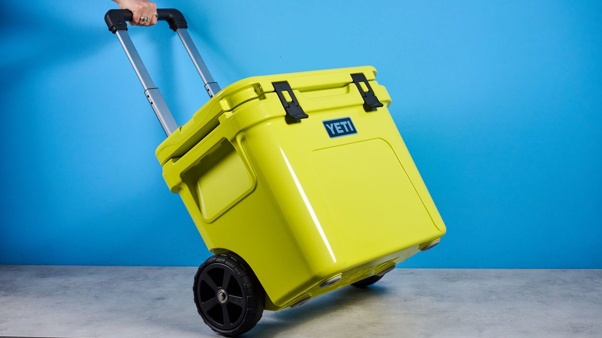 the yeti roader cooler in neon yellow with wheels, soft close hinges, a retractable handle, and 32 quart capacity