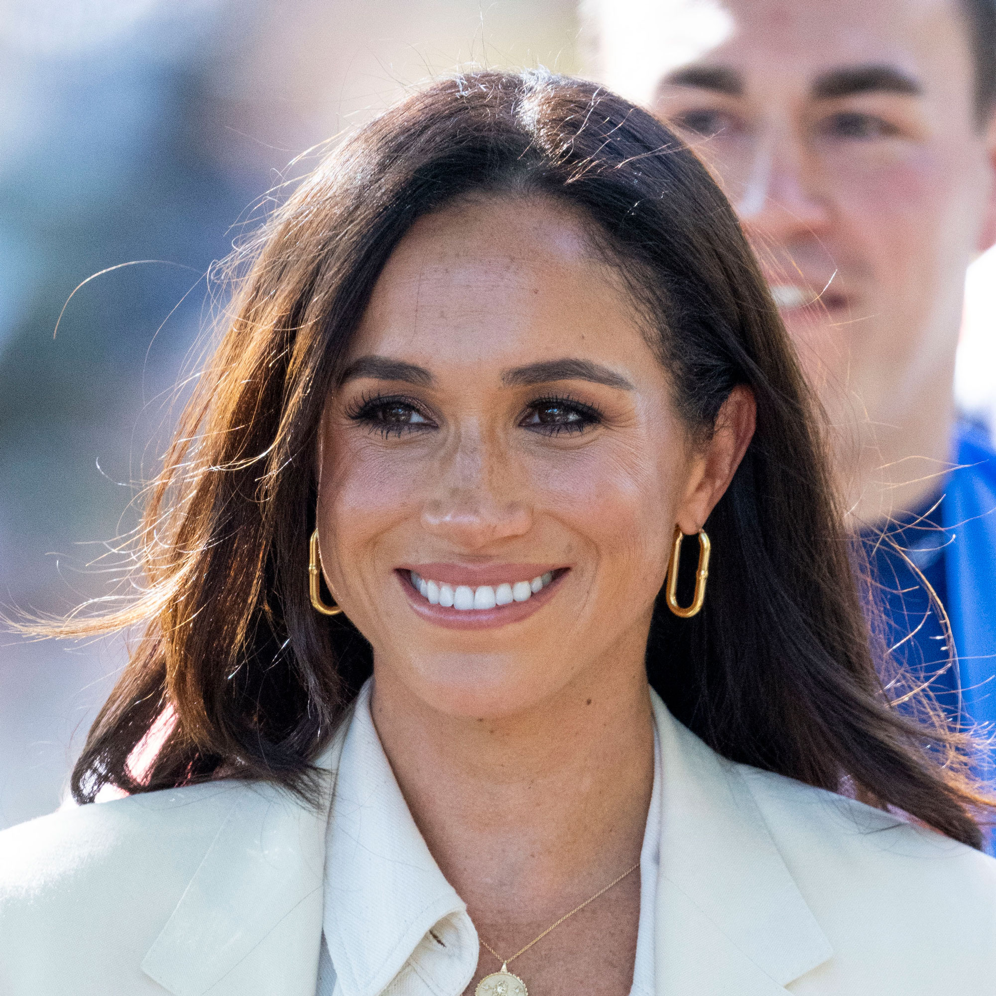 Meghan Markle looks away from the camera and smiles