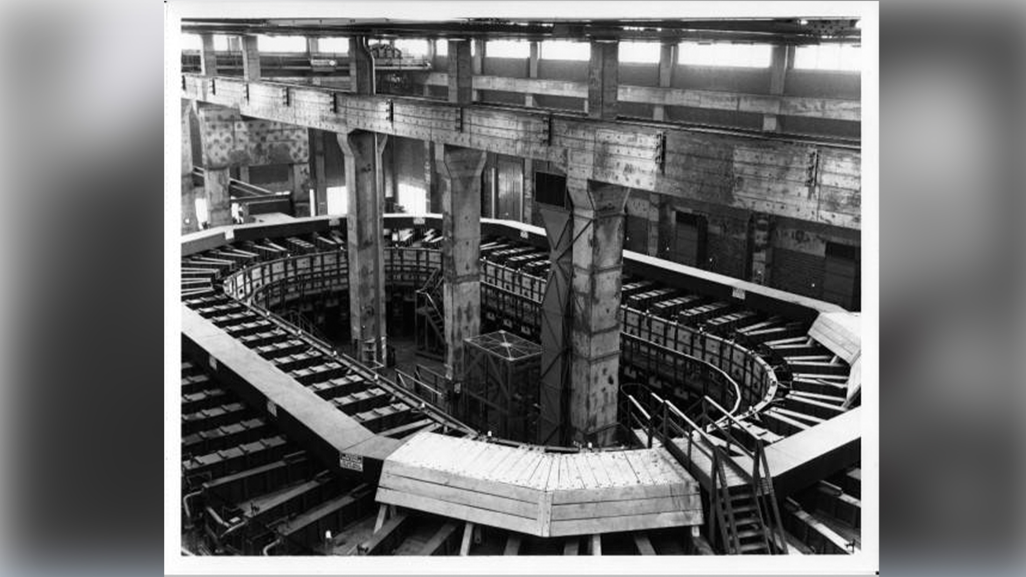 A circular racetrack-like machine in a warehouse.