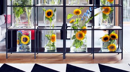 sunflowers in vases on a shelving unit