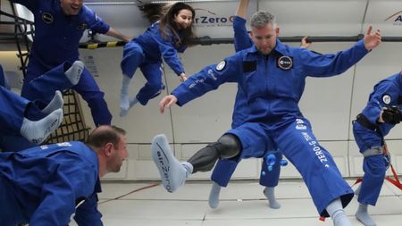 John McFall floating in zero-G in an airplane with other prospective astronauts