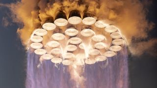 close-up shot of all 33 of the first-stage engines of SpaceX's Starship first stage burning as the vehicle rises off the launch pad.