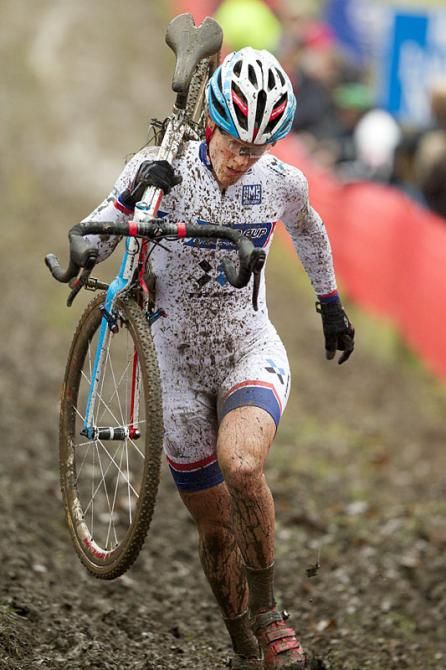 Katie Compton runs with her bike