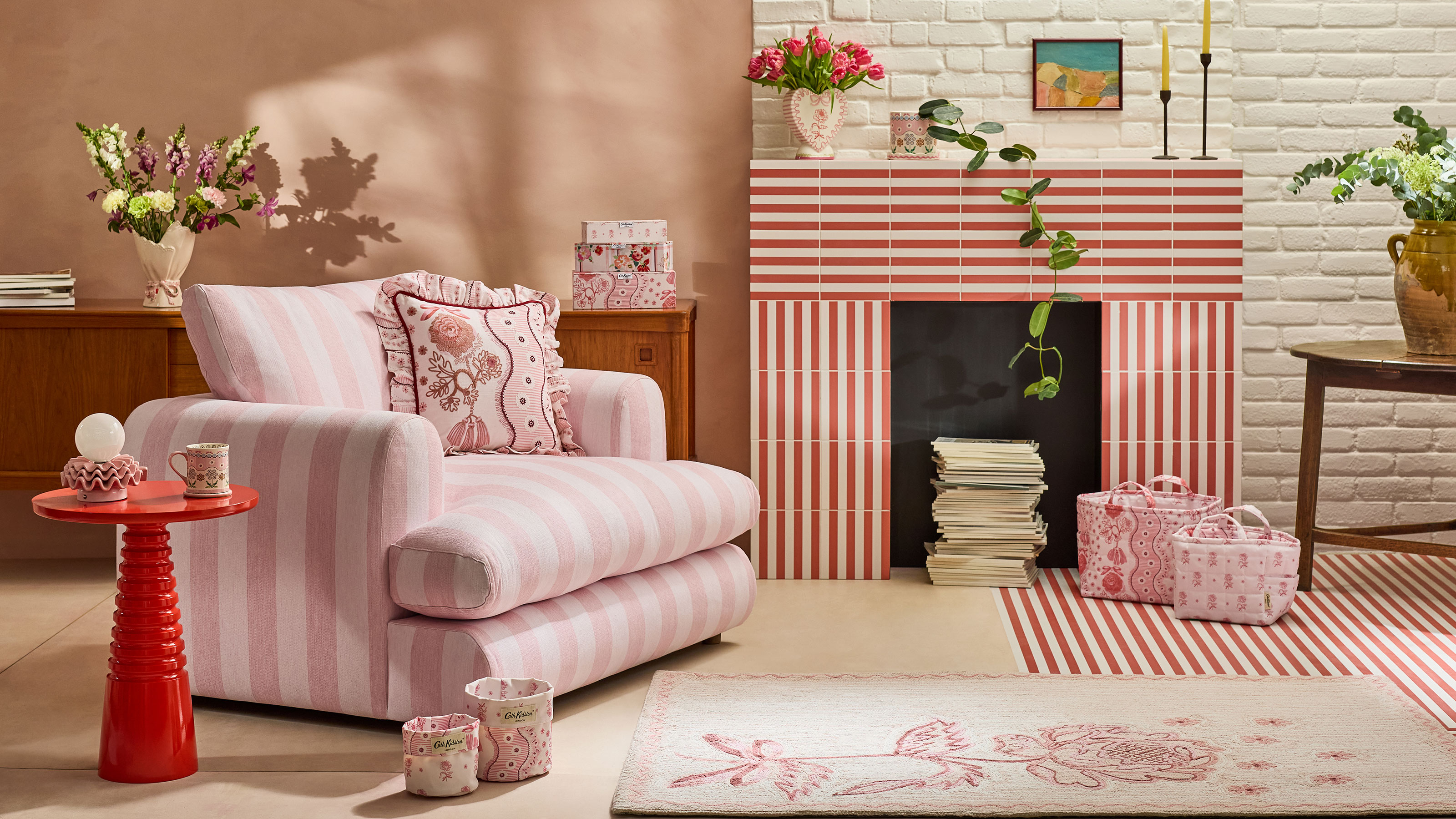 Living room with pink wall and white painted bricks with pink and white stripe armchair and striped fireplace