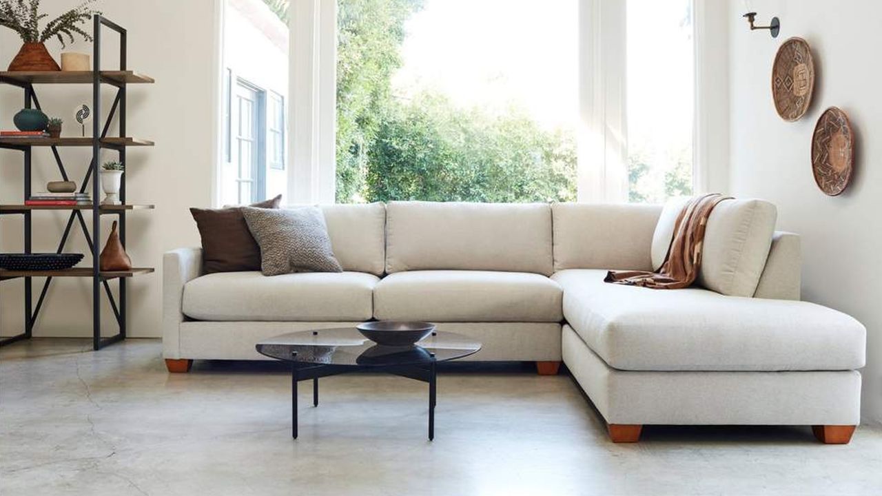 An off-white sleeper sectional in a modern living room