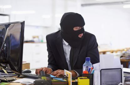 Shot of a hacker dressed in a black mask hacking a computerhttp://195.154.178.81/DATA/i_collage/pi/shoots/783303.jpg