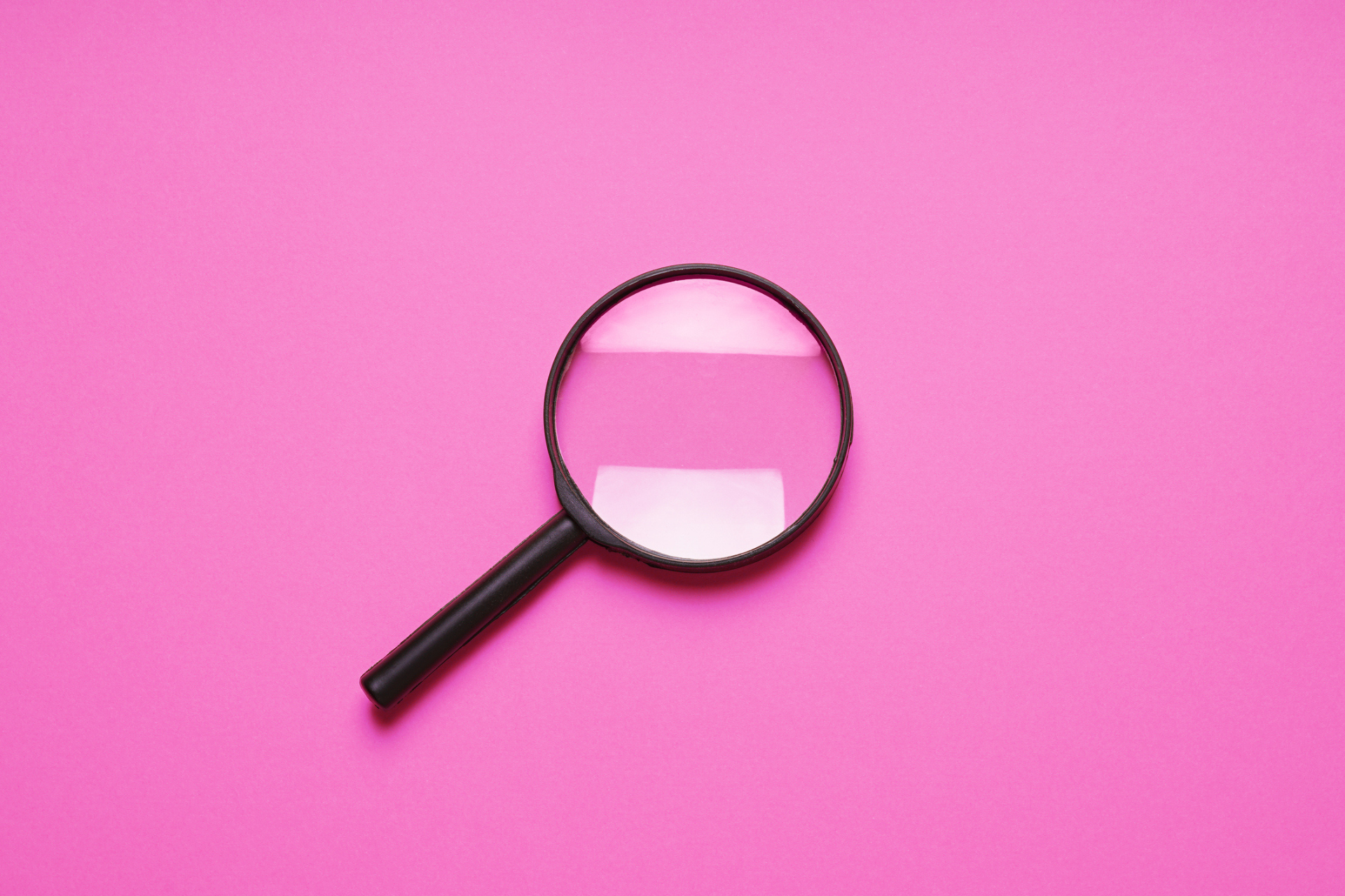 Magnifying glass on pink background