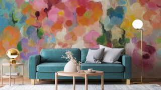 Vibrant colourful wall mural behind teal coloured sofa