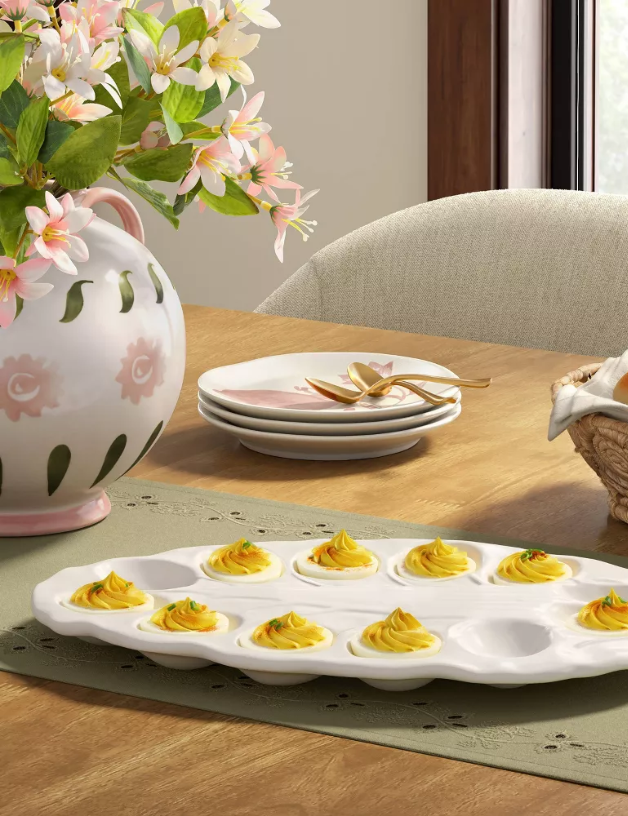 Easter tablescape featuring a pink-and-green painted ceramic vase holding fresh blooms, green eyelet lace table runner, and radicchio-style egg plate holding deviled eggs.