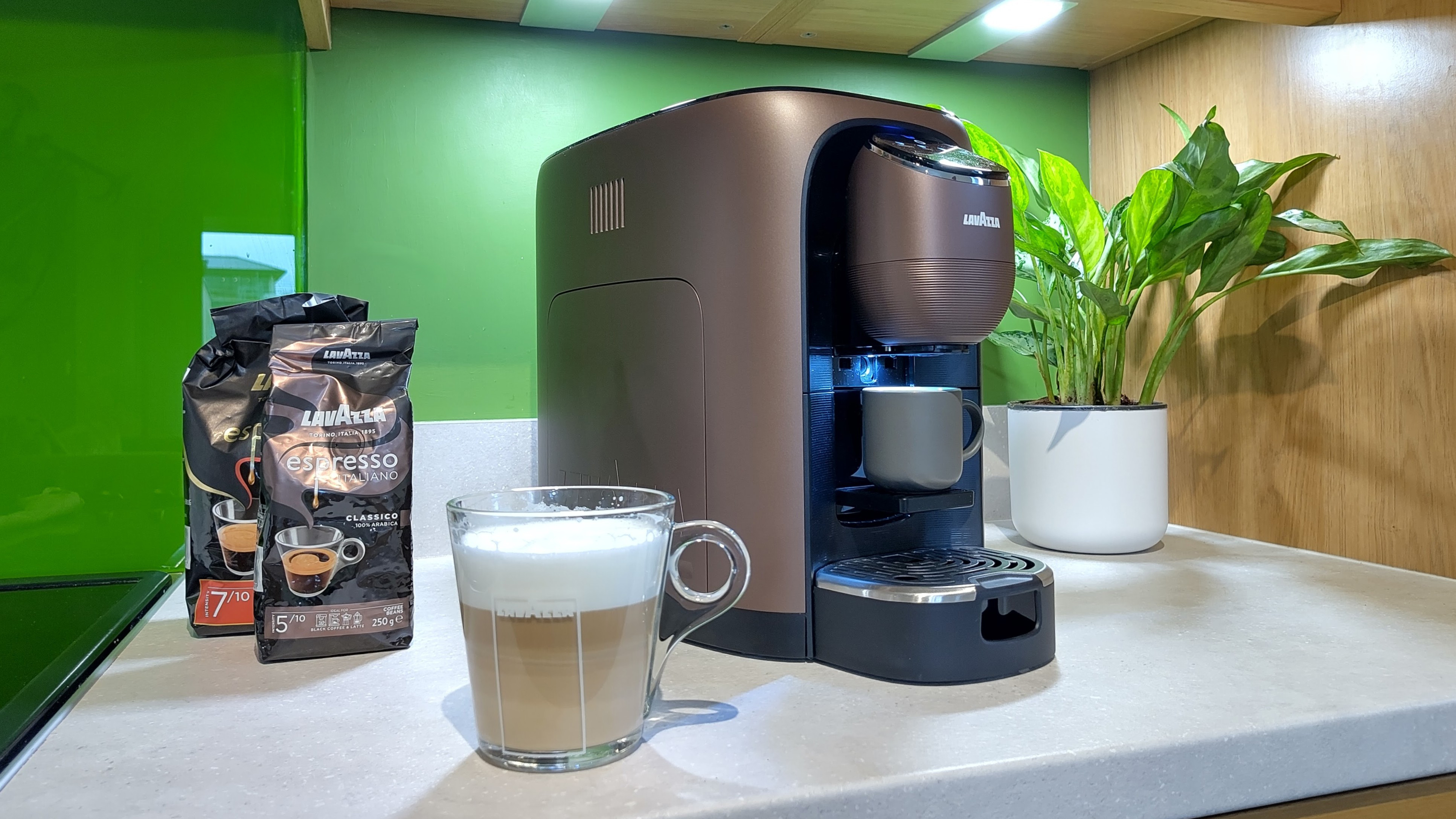 Lavazza Assoluta coffee machine with drink and two bags of coffee