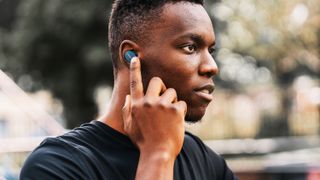 Bose Sport Earbuds worn by a young man outdoors