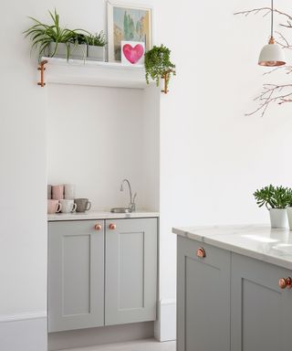 kitchen area with white wall and cabinet