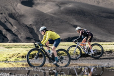 Cecily Decker (Scuderia Pinarello) leads Karolina Migon (PAS Racing) across the lava rocks at 2024 The Rift Gravel