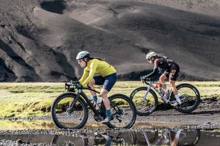 Cecily Decker (Scuderia Pinarello) leads Karolina Migon (PAS Racing) across the lava rocks at 2024 The Rift Gravel