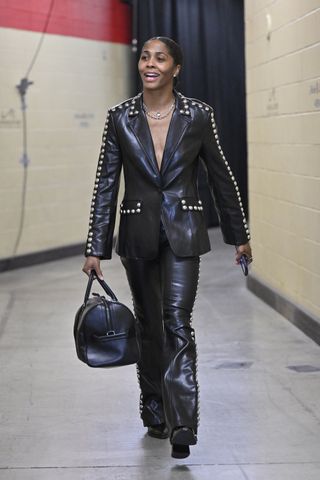 Sydney Colson #51 of the Las Vegas Aces does a tunnel walk at the 2024 WNBA finals wearing a studded leather suit