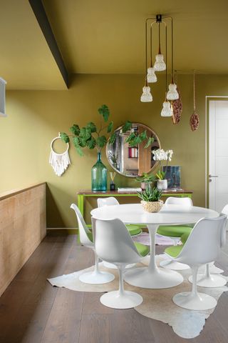 Olive green dining room with white modern dining table and chairs