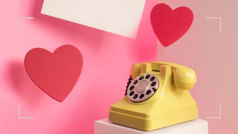 yellow phone surrounded by red hearts on pink background