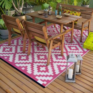 coloutful outdoor rug underneath a dining table and chairs