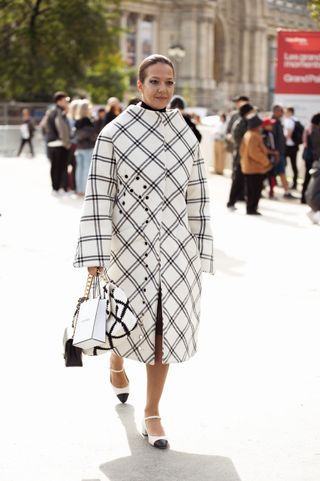 a woman wears cap-toe shoes in Paris