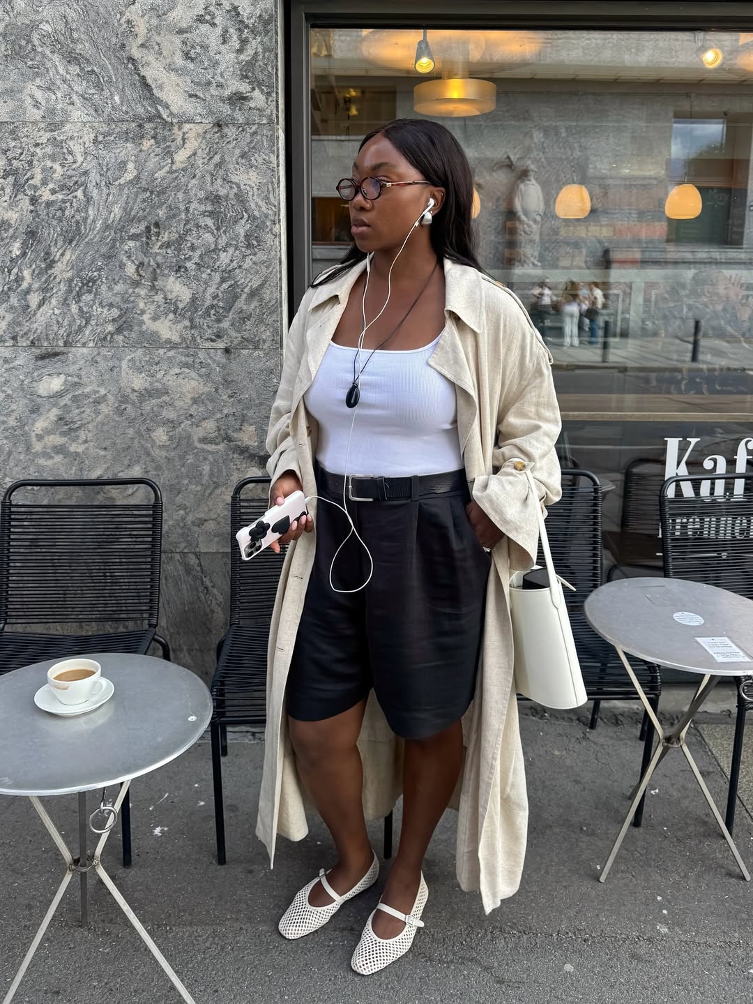 Nnenna in a trench, shorts and mesh shoes