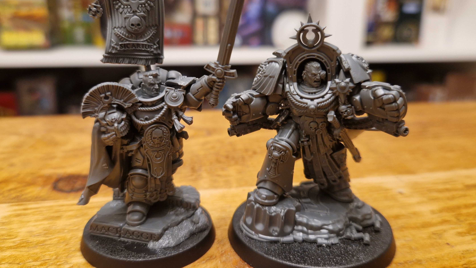 Cato Sicarius and Marneus Calgar miniatures on a wooden table