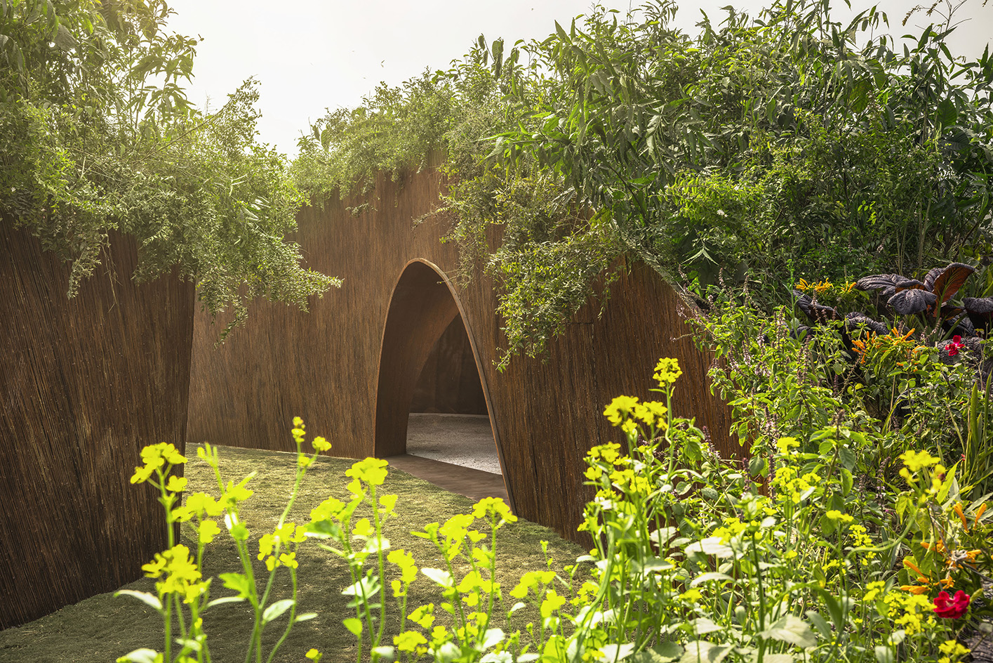 The Aranyani Pavilion seen in its green setting that highlights its natural materials and organic construction