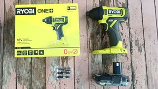 Ryobi ONE+ Cordless Impact Driver box contents laid out on a table