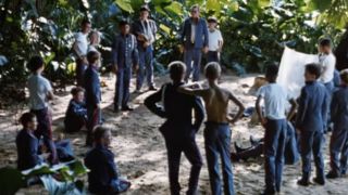 A scene with a bunch of boys standing around in Lord Of The Flies