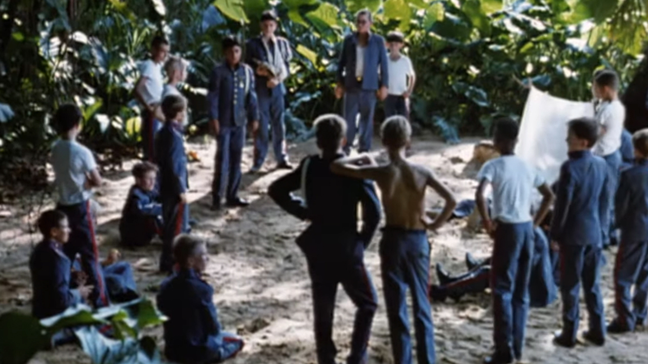 A scene with a bunch of boys standing around in Lord Of The Flies