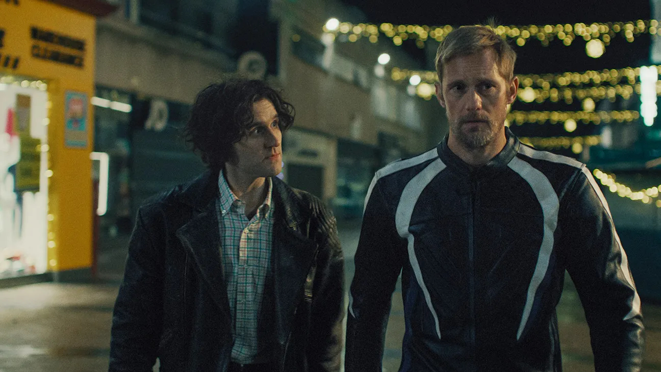 Harry Melling and Alexander Skarsgard in 'Pillion' walking down a london street