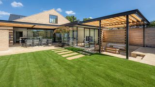 A beautifully green lawn in a modern garden with sunken patio