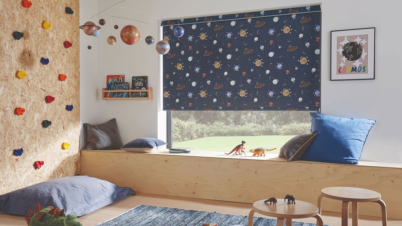 Kids room with planet print roller blind and climbing wall 