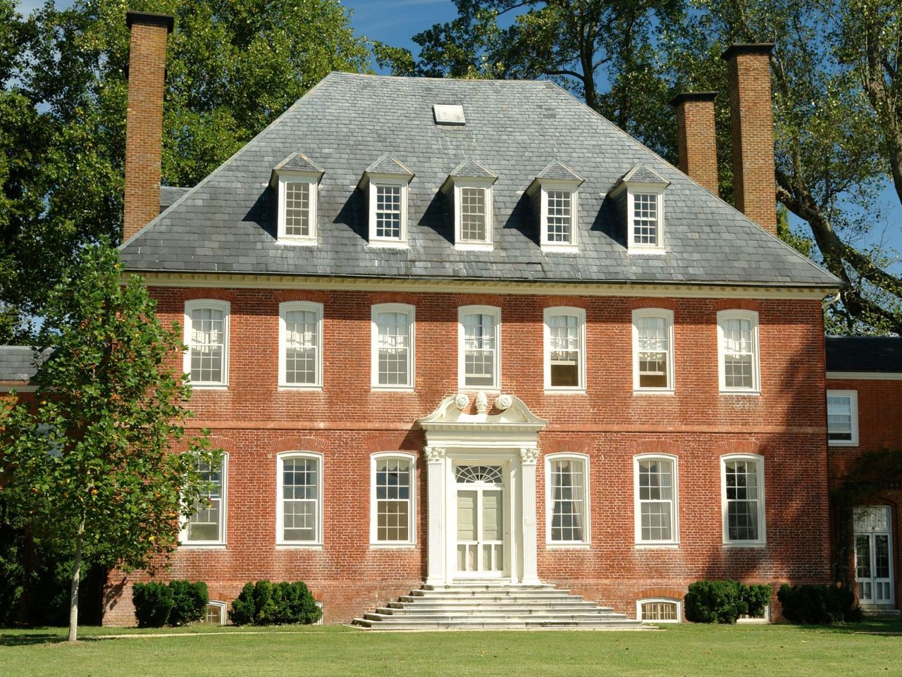 Georgian red brick mansion with chimneys and dormer windows