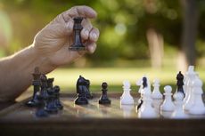 Active retired persons, hand of old man holding chess piece in park. Closeup shot, copy space