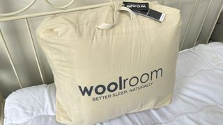 woolroom packaged mattress topper on bed
