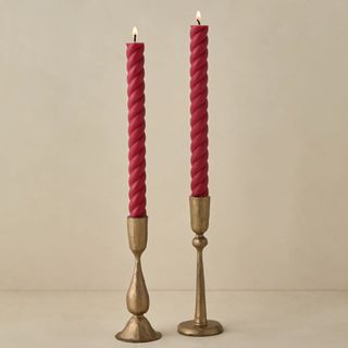 pair of red taper candles in brass stands