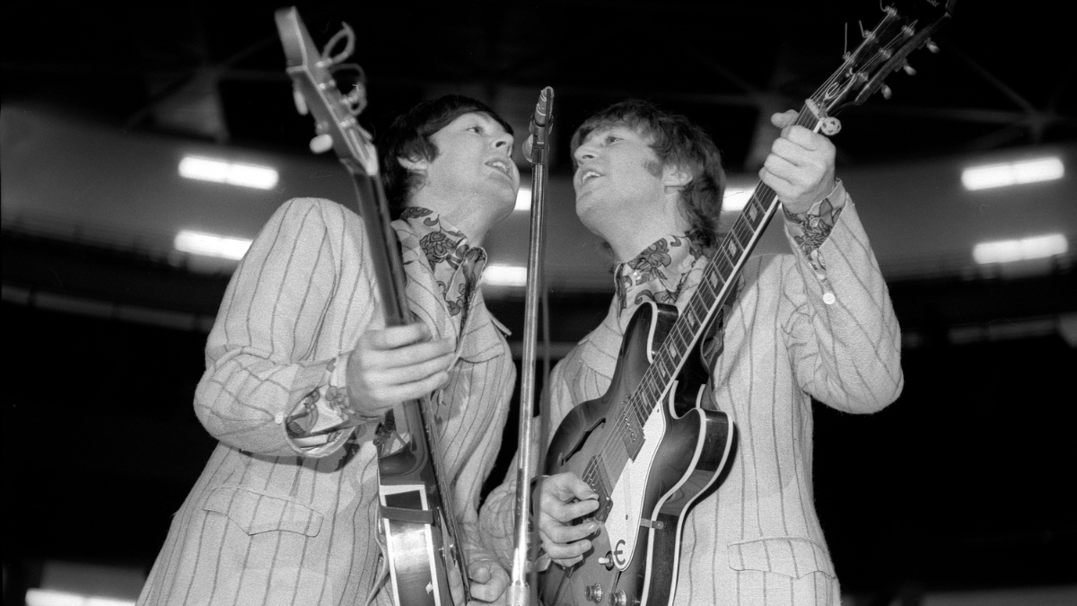 Paul McCartney (left), on bass, and John Lennon (1940 - 1980), on guitar, both of the group the Beatles, as they perform onstage at Olympia Stadium, Detroit, Michigan, August 13, 1966