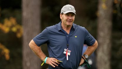 Nick Faldo stands and watches on at Augusta National